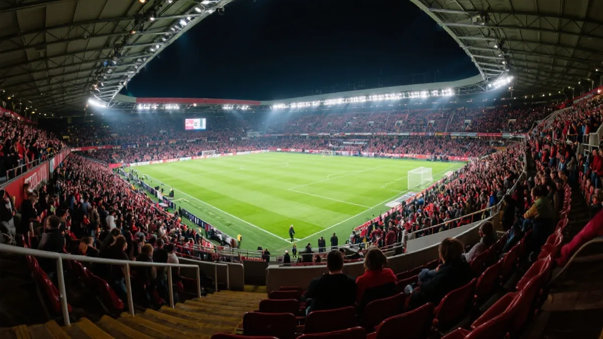 俯瞰足球场与满座看台的广角视角，氛围热烈、充满期待